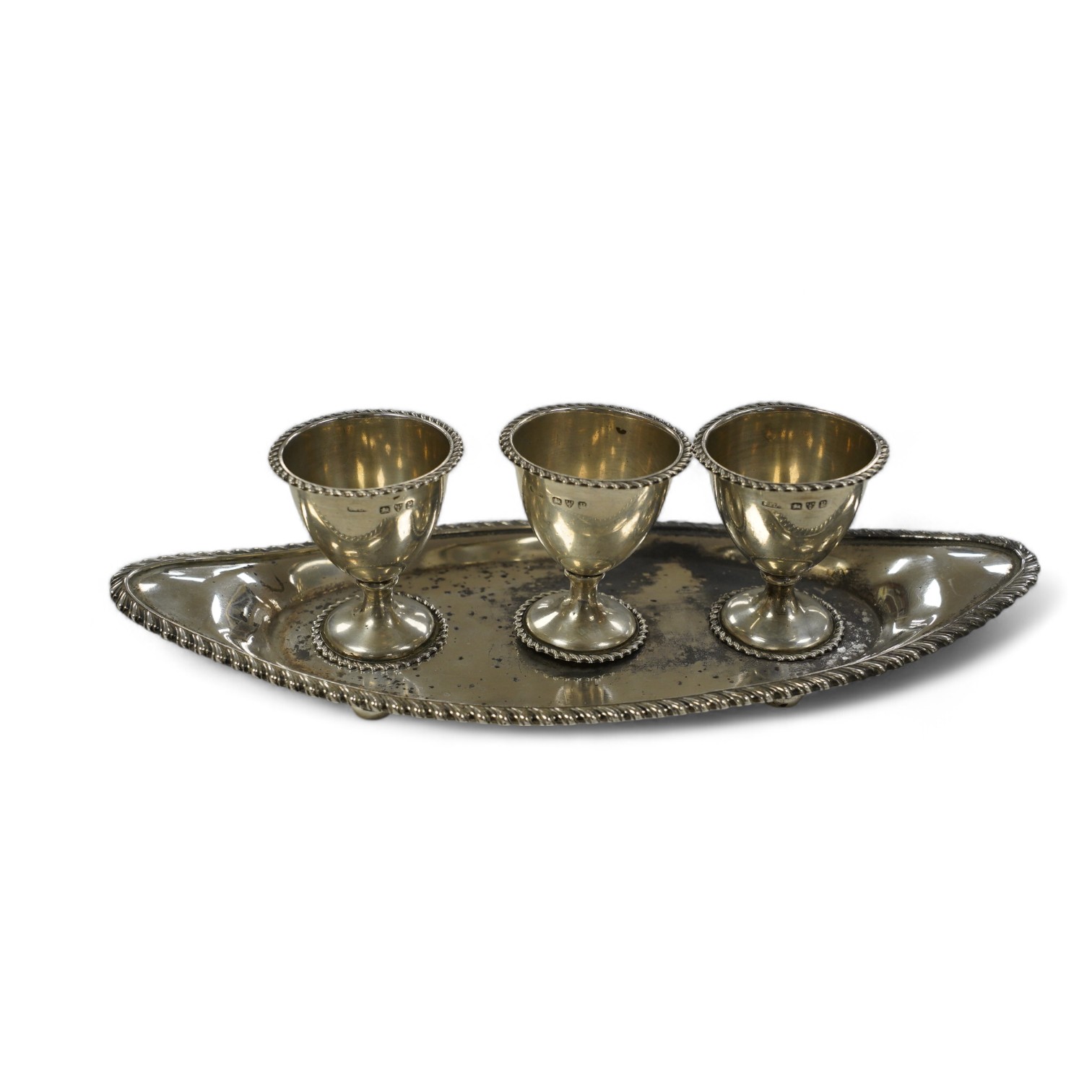 A late Victorian silver egg cruet, with three cups on a navette shaped stand, Chester, 1898, 25.8cm, 10.9oz. Condition - poor to fair